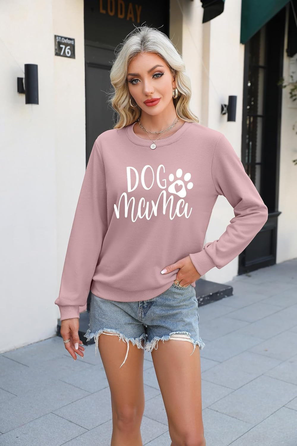 Dog mom sweatshirt in pink with a white paw graphic.